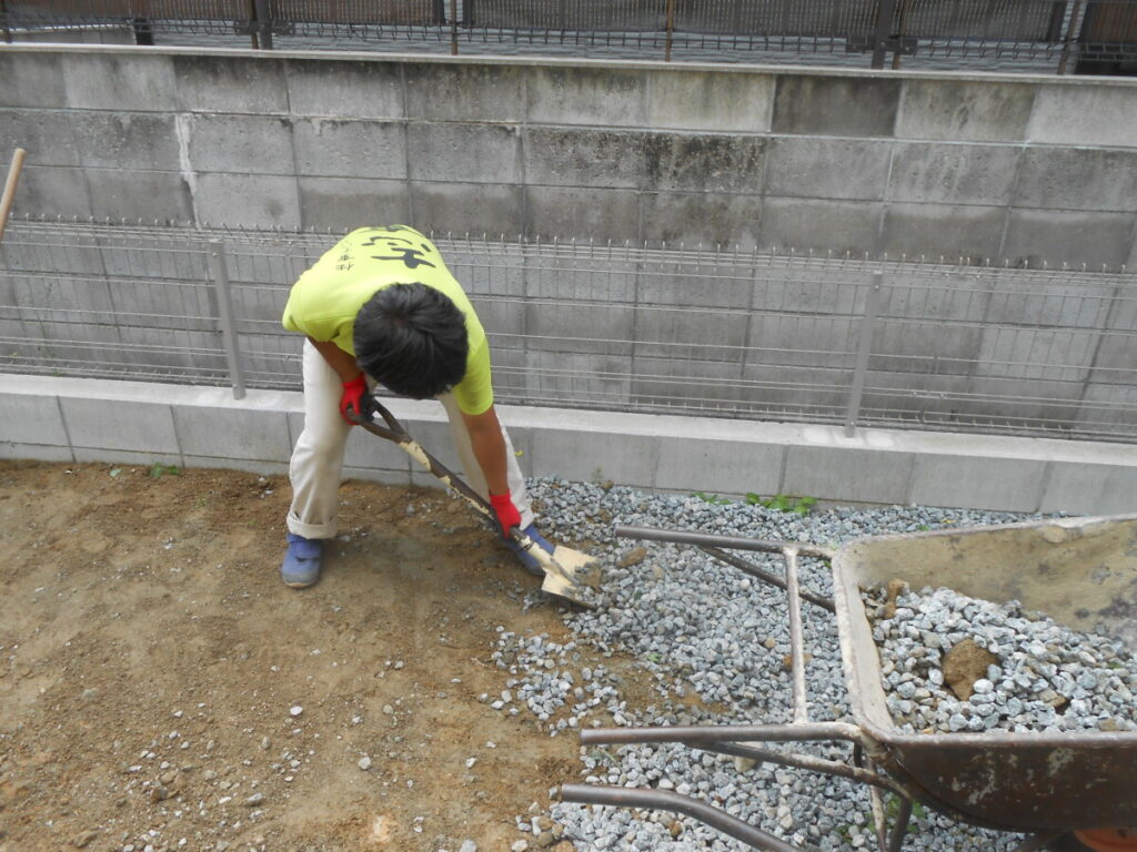 尖った砕石を手作業で丁寧に取り除く様子