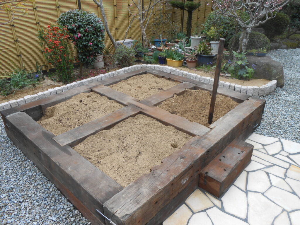 枕木で作られた高さのある花壇。腰掛けて楽な姿勢でガーデニングができます