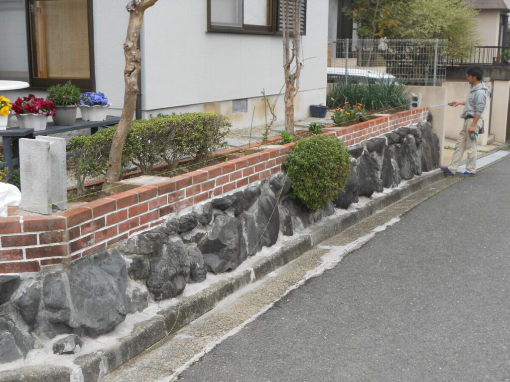 ご主人様手作りのレンガ塀を残して行うメッシュフェンス設置工事の様子