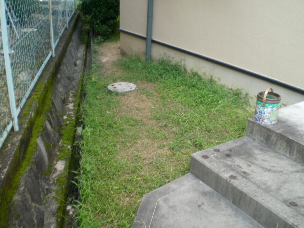 雨の日にぬかるむ土の状態の勝手口前