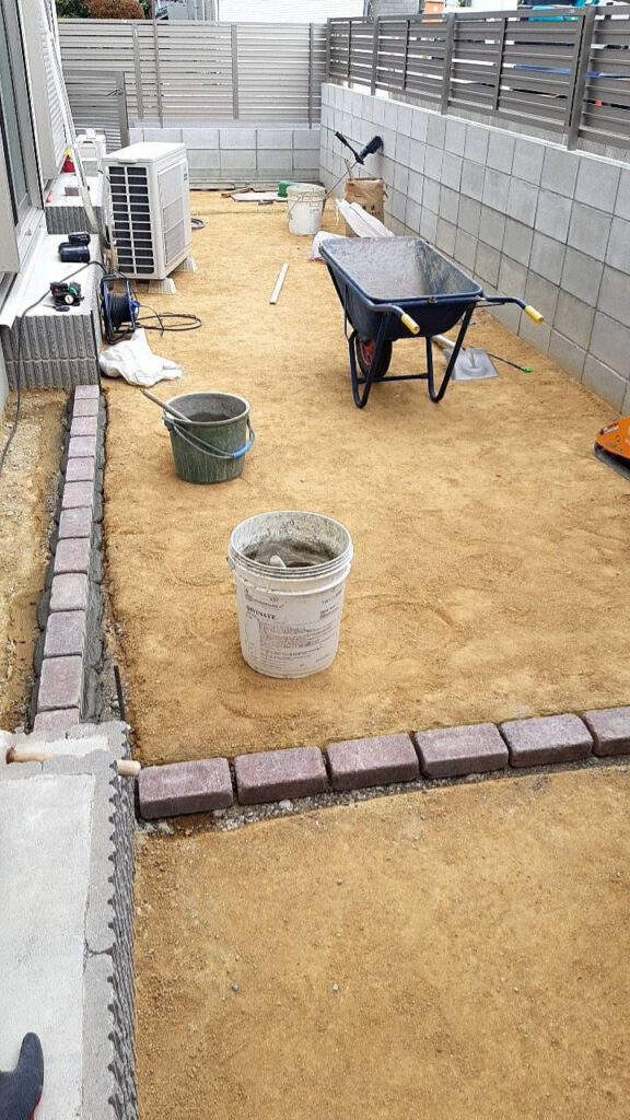 レンガの縁が角まで並び終わり、芝を張る範囲が決まった庭