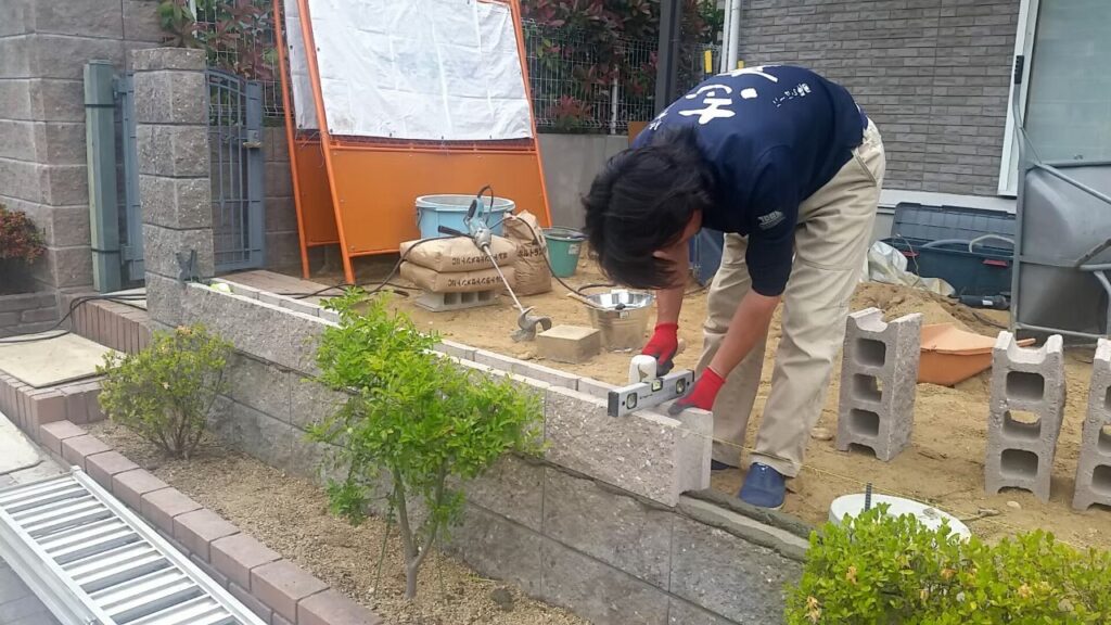 積んだブロックをモルタルで固めている職人の作業