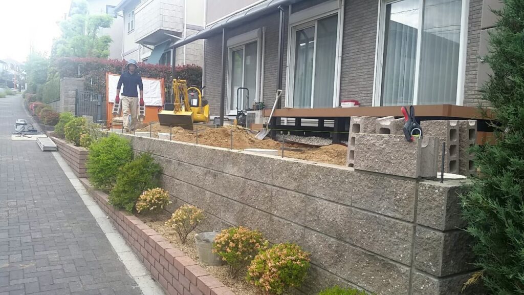 道路側から見た、既存の塀の上に化粧ブロックを積み上げているところ