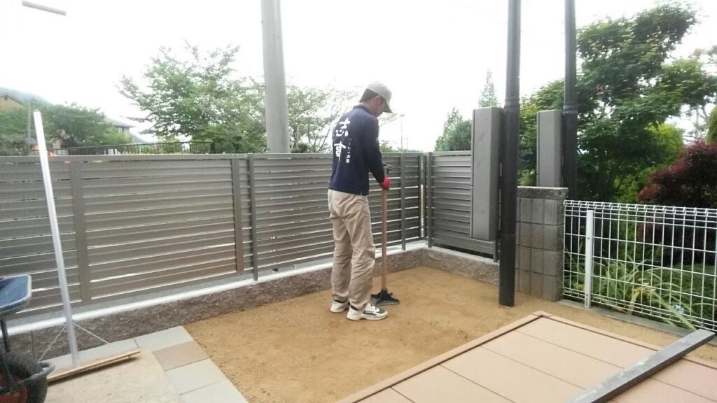 鋤き取ったあとに真砂土を入れ、人工芝の下地を整えているところ