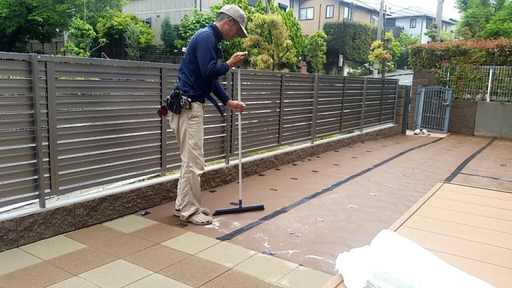 トンボで真砂土を平らに均している職人の作業