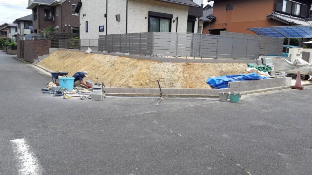 道路との境に土留めブロックの一段目を積んでいるところ。西側から見た遠景