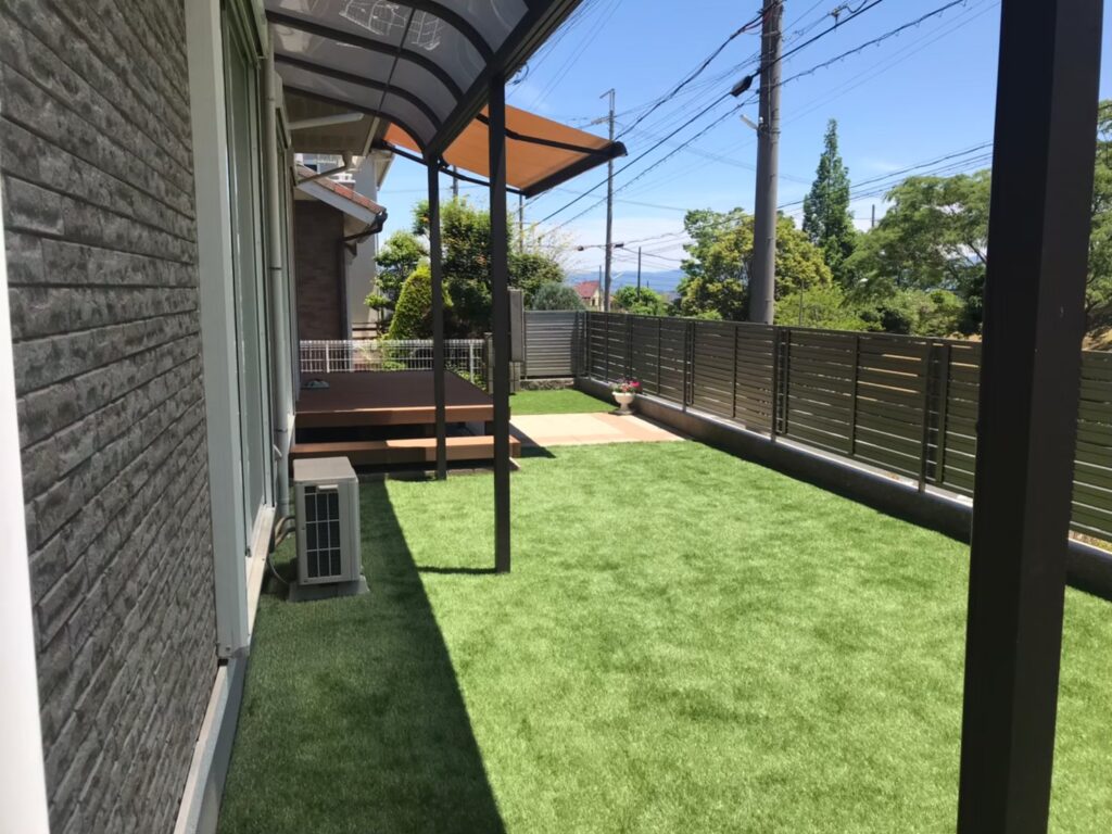完成後の庭をテラス下から見たところ。人工芝と目隠しフェンスで囲まれた空間